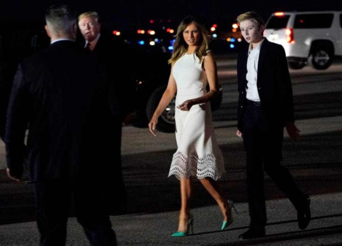 US President Donald Trump and his son Barron wave as they board Air Force One at Morristown Municipal Airport in Morristown, New Jersy, on August 16, 2020. (Photo by JIM WATSON / AFP)