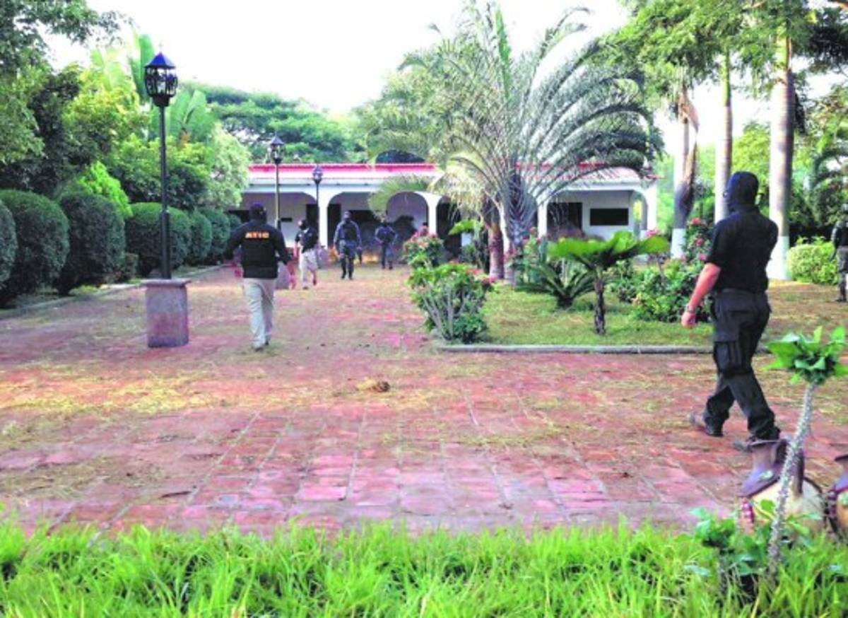 Agentes de la ATIC y de la PMOP al momento de ingresar a una de las lujosas residencias.