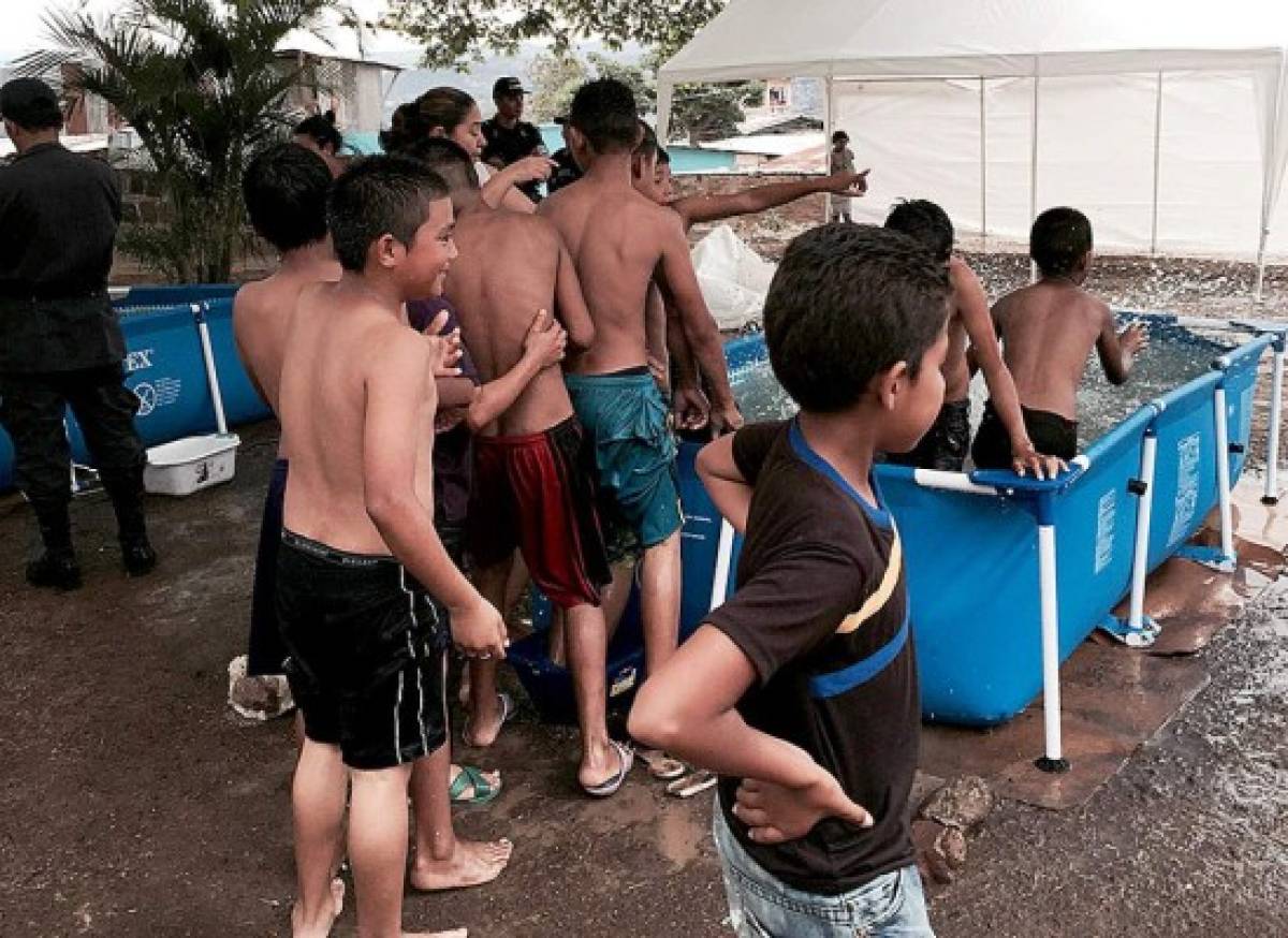 Honduras: Policías instalan piscinas para que niños bañen