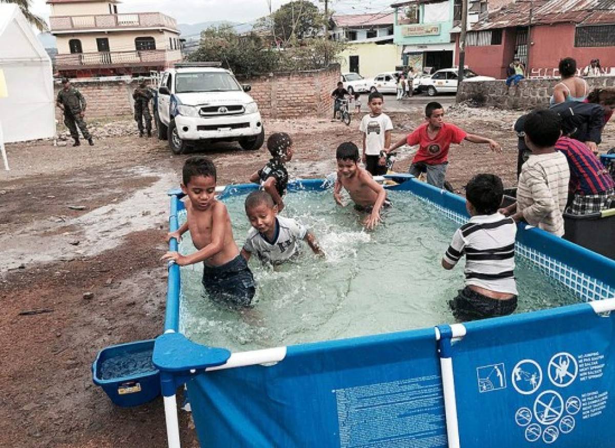 Honduras: Policías instalan piscinas para que niños bañen