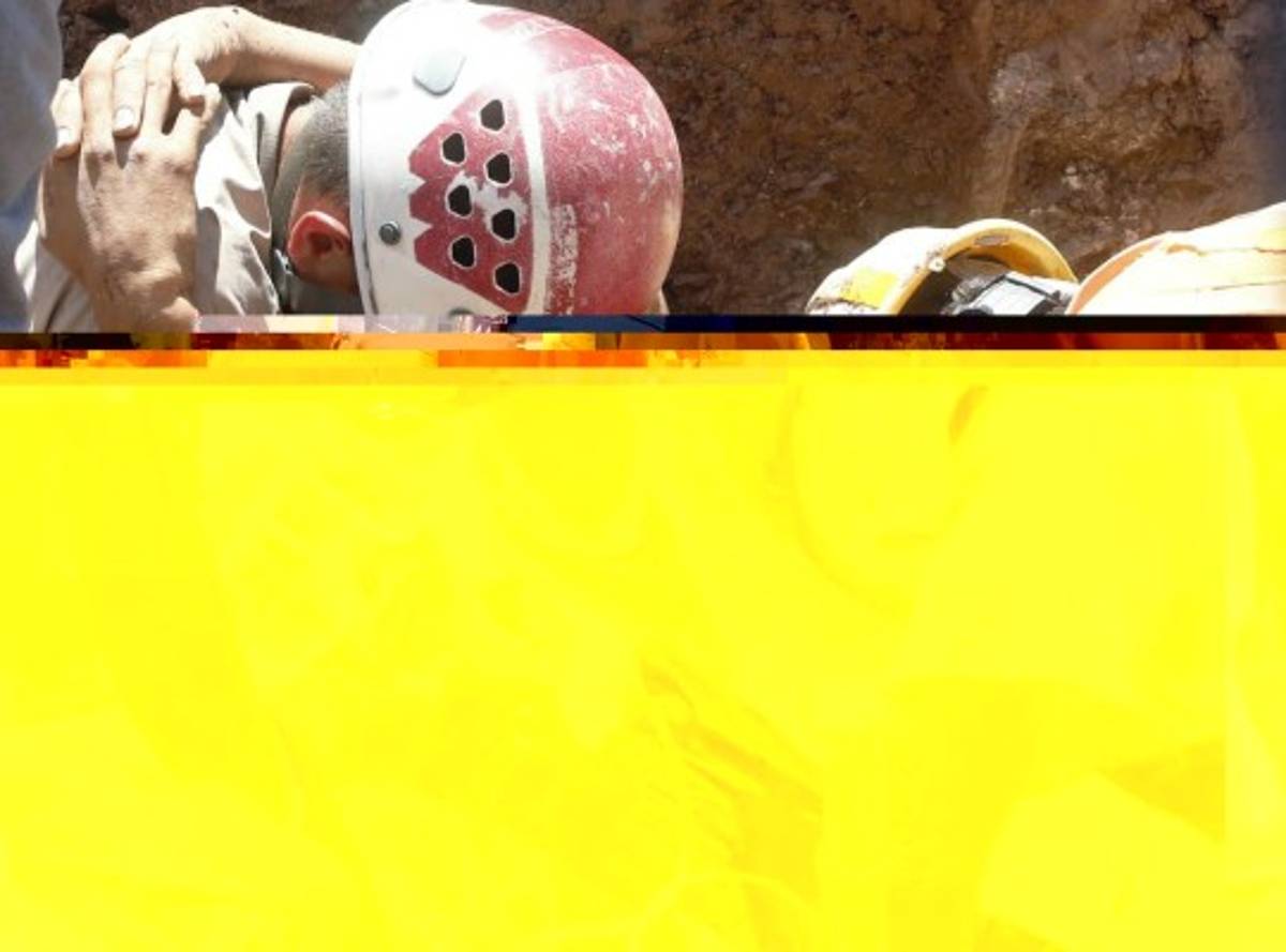 Julio César Gálvez Sierra, de 29 años, murió soterrado en el bulevard Kuwait de la capital hondureña. En este momento, aún con vida, el obrero se aferraba de forma dramática a un bombero (Foto: Estalin Irías/ EL HERALDO).