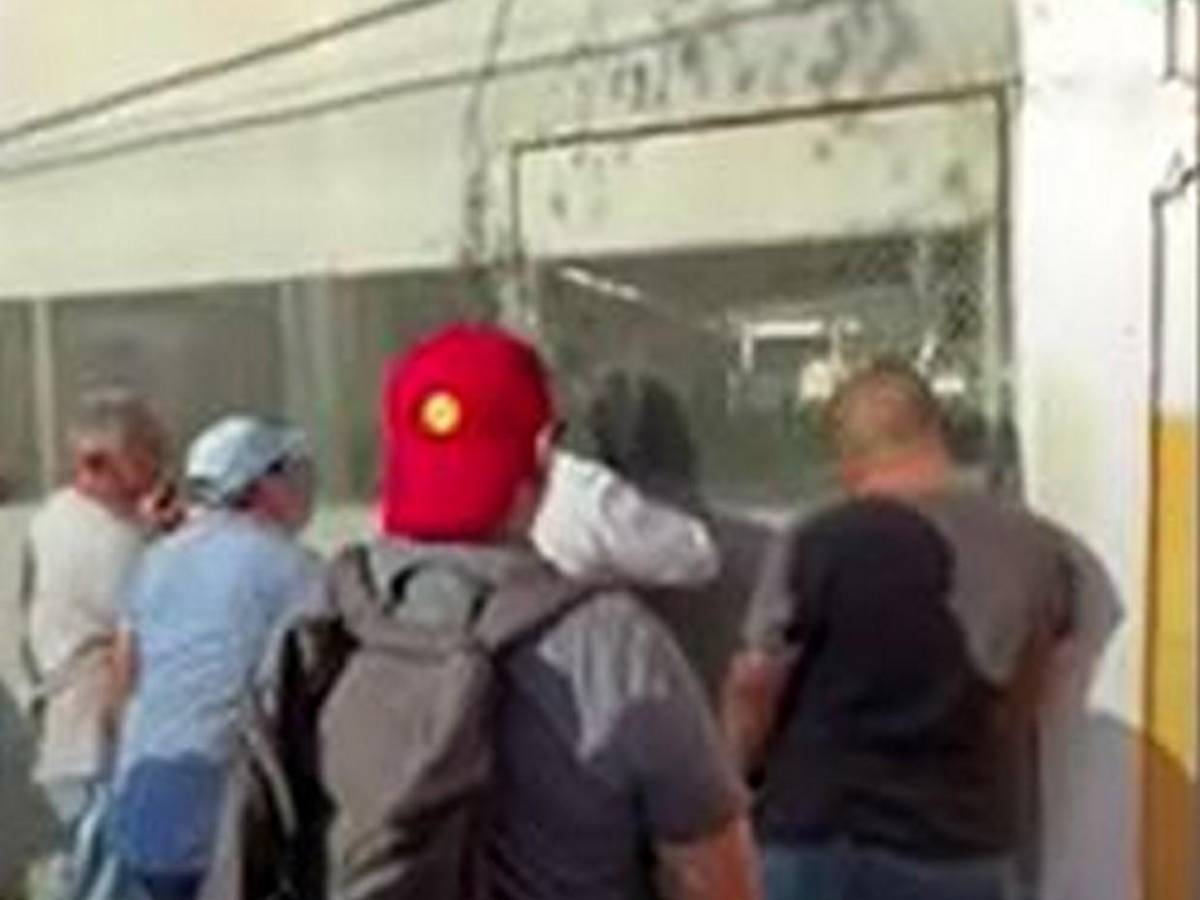 Roberto Contreras golpea portón de centro de votación que tardó en abrir urnas