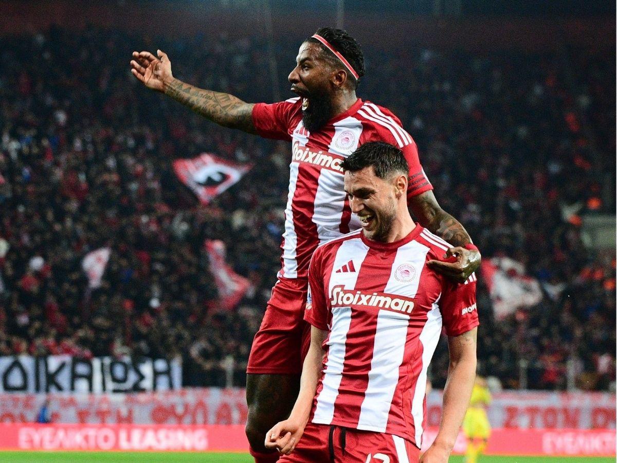 Luis Palma anota su primer gol con el Olympiacos y lo celebra frente a jugador mexicano