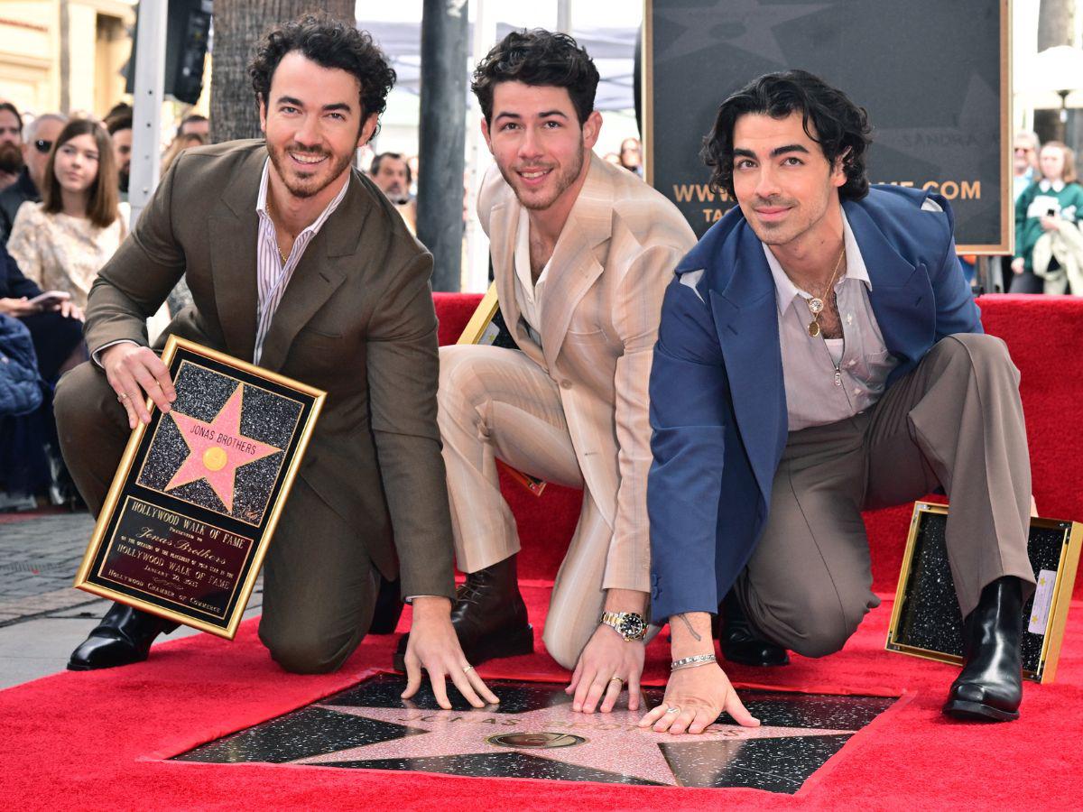 Los Jonas Brothers posando junto a su estrella en el famoso paseo de Hollywood.
