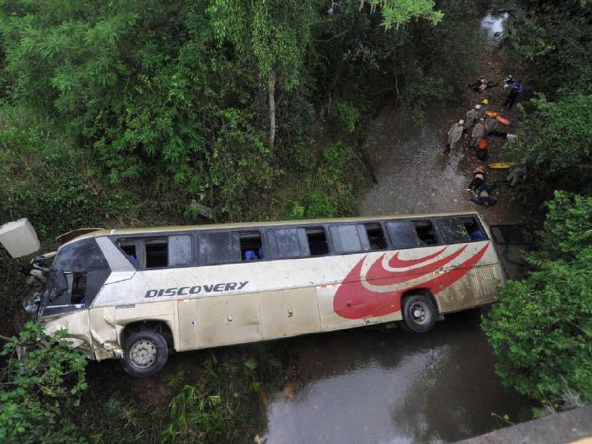 Así quedó el autobús de la empresa Discovery tras el fuerte accidente. En los alrededor se observa a varias víctimas dispersas, siendo asistidas por paramédicos.