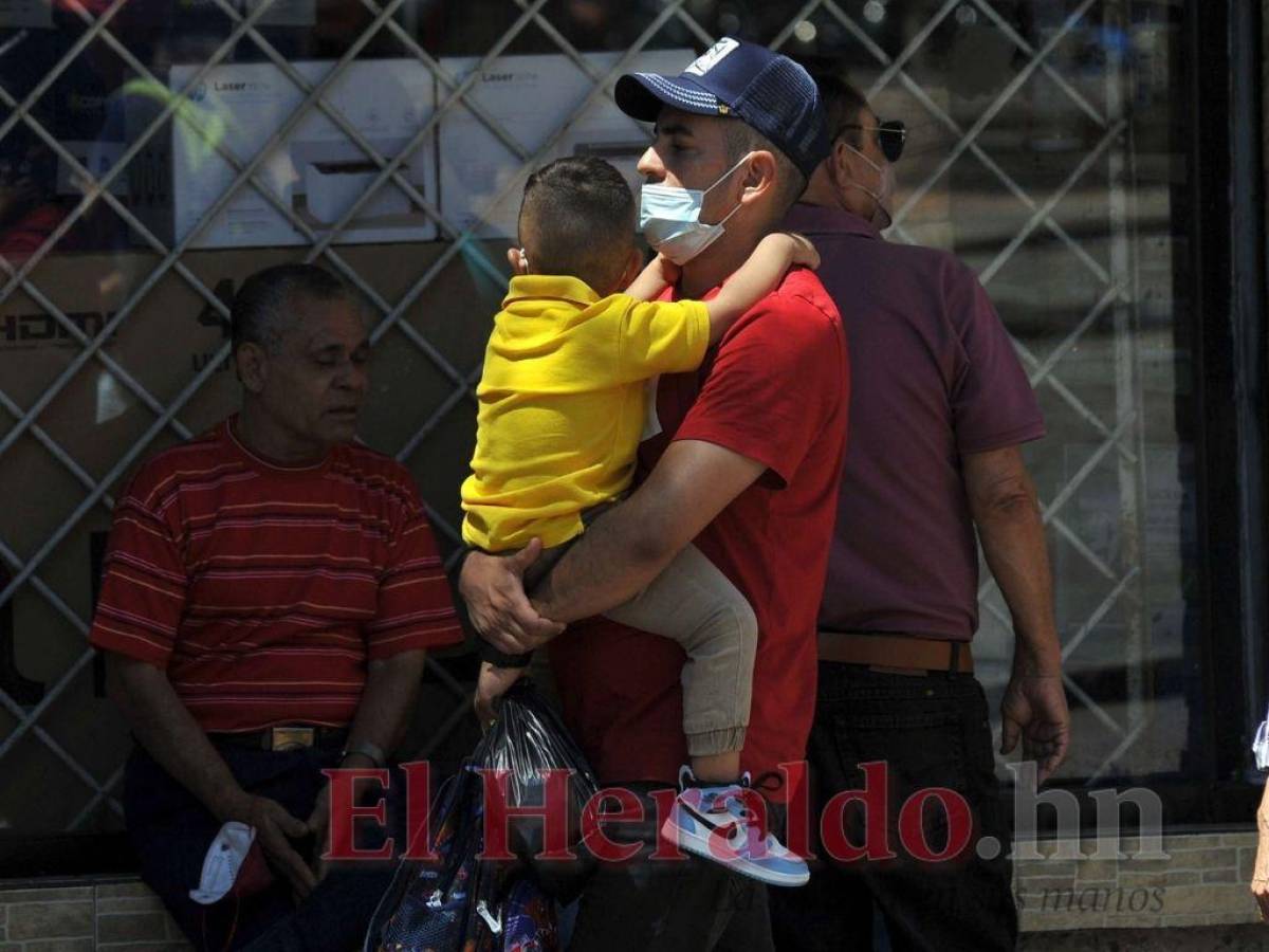 Un pequeño se aferra a los brazos de su papá.