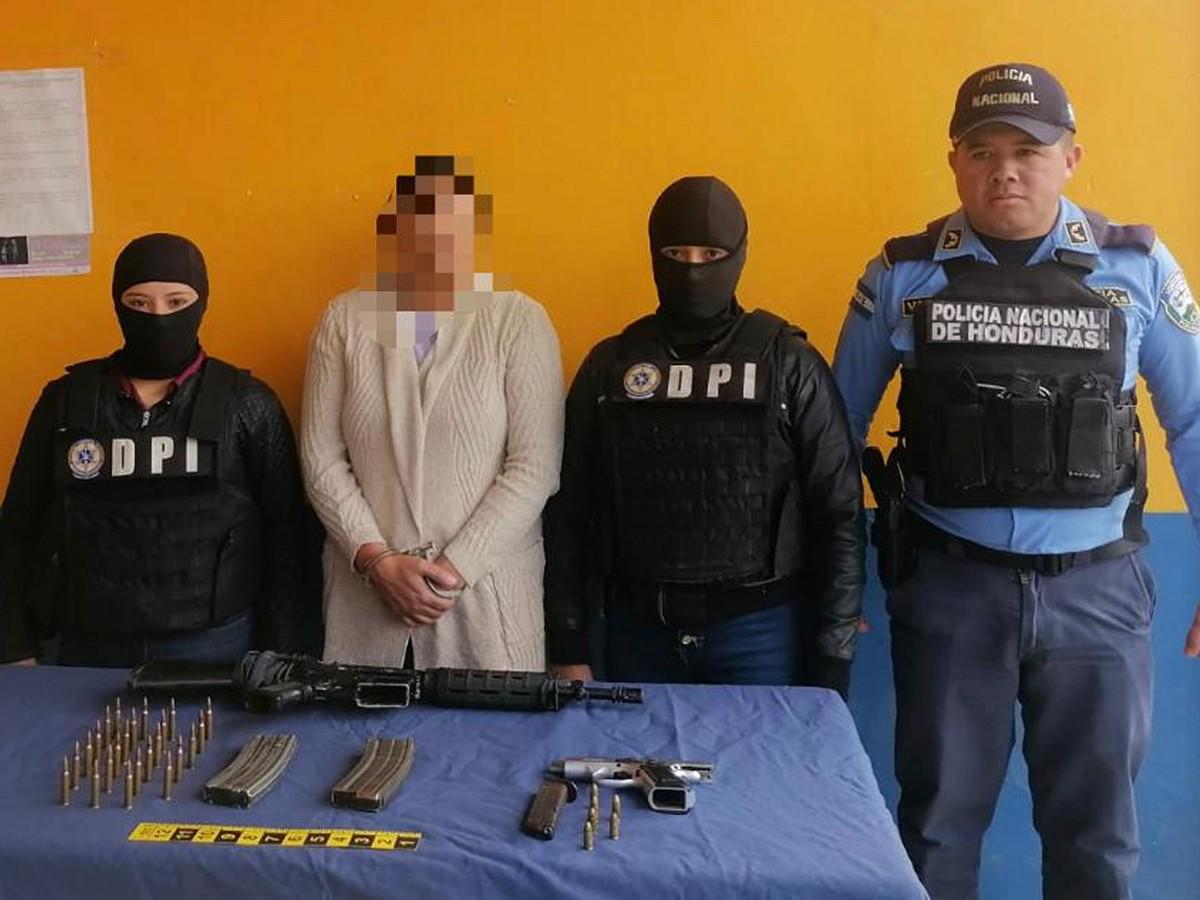 La mujer fue presentada por la policía junto a las armas que se le decomisaron.