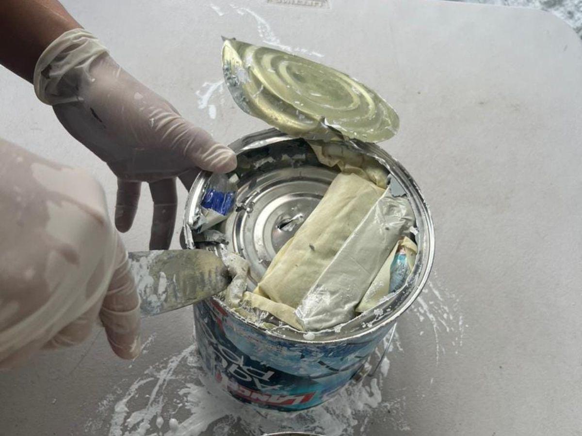 Así descubrieron los agentes la droga y el resto de objetos en las latas de pintura.