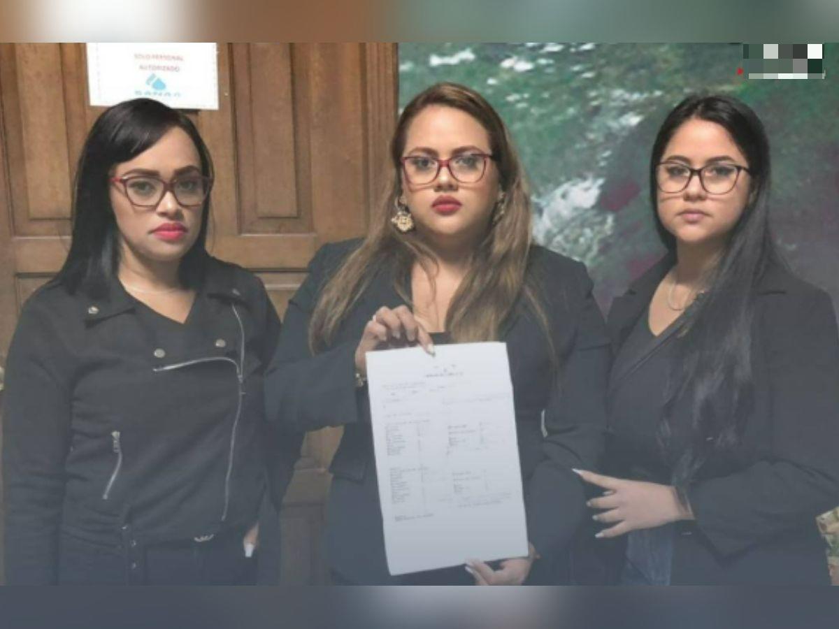 Estefany Núñez (centro) y dos de sus compañeras sostienen la denuncia hecha ante el Ministerio Público por acoso laboral vertical.