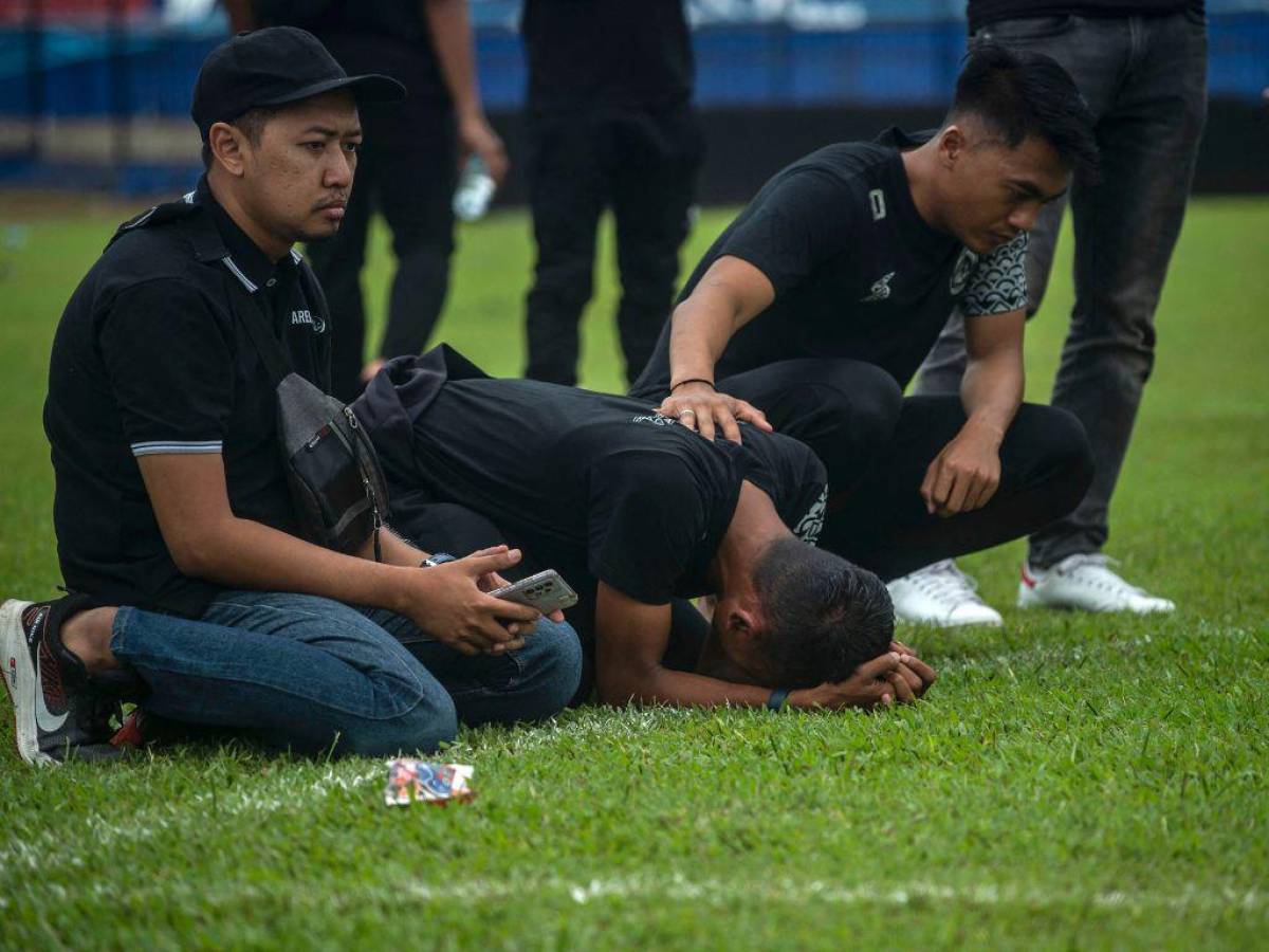 Los jugadores y directivos del Arema Football Club se reúnen para rezar en la cancha por las víctimas de la estampida en el estadio Kanjuruhan en Malang, Java Oriental, el 3 de octubre de 2022.