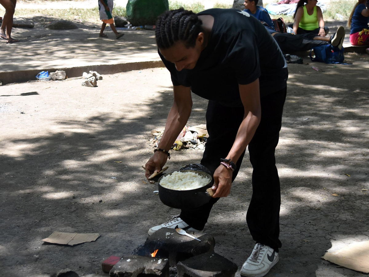 Con ladrillos y cartones los migrantes se ayudan para construir una pequeña “estufa” para preparar sus alimentos.
