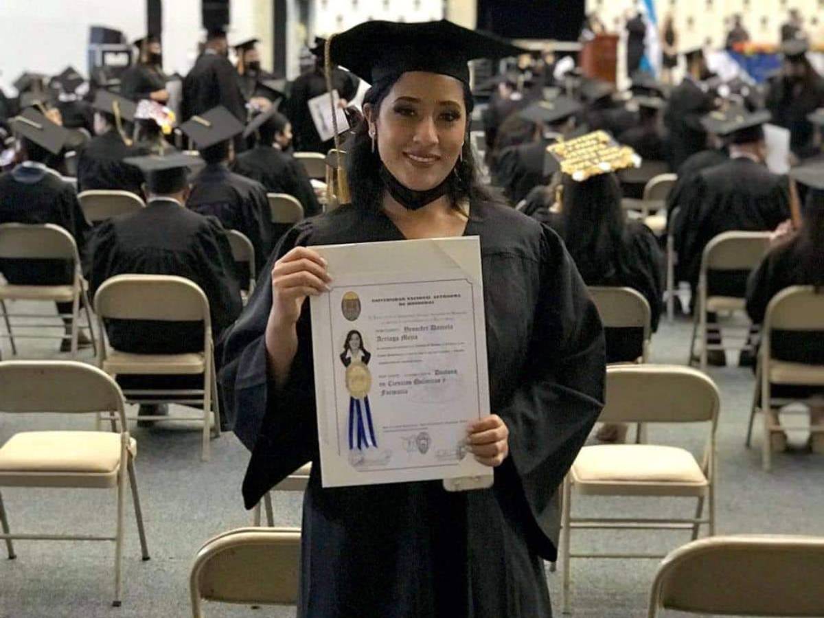 Jennifer sostiene con alegría su título que la certifica como profesional.