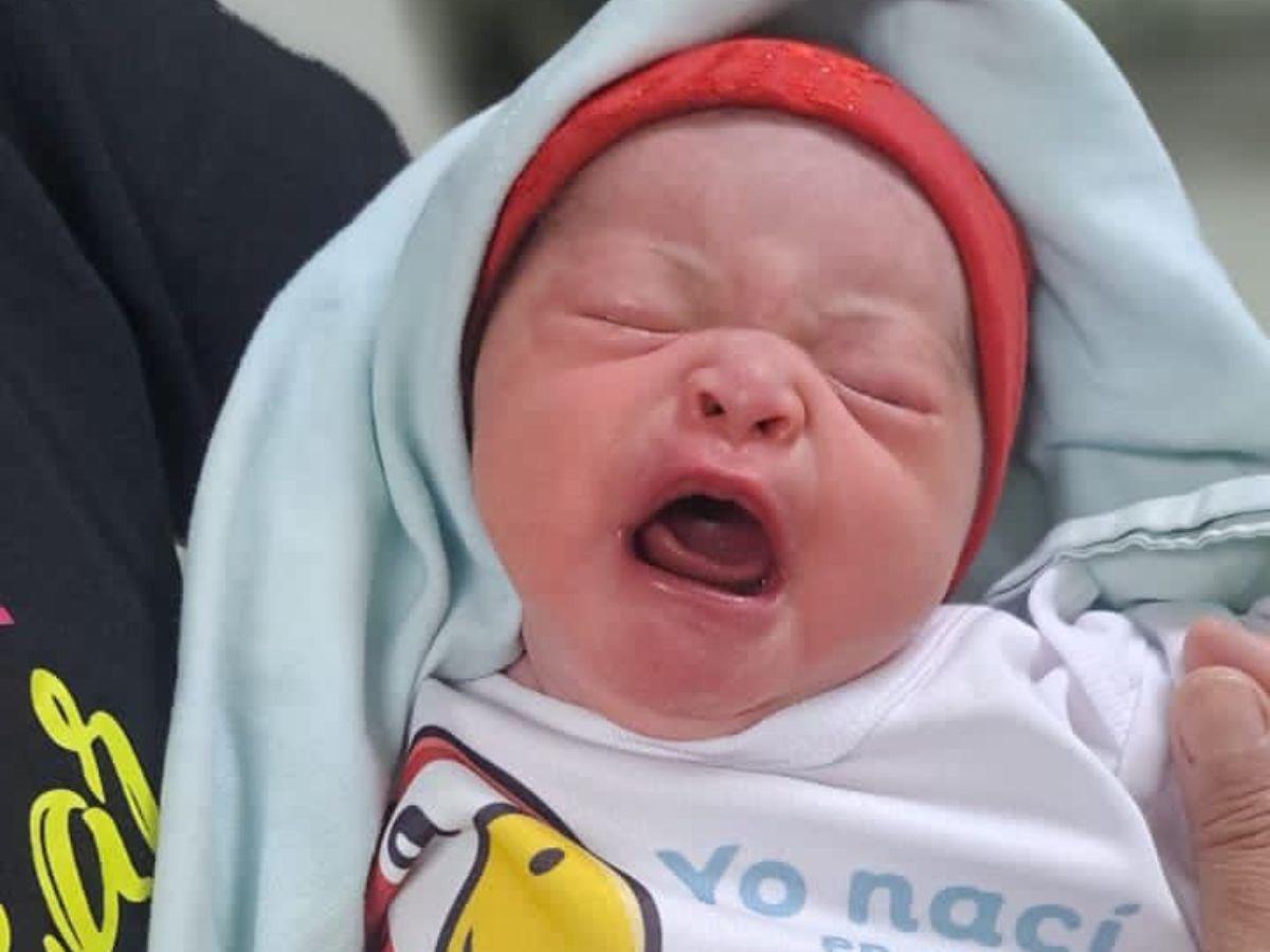 En brazos de su feliz madre, una joven de 21 años, esta pequeña llegó para completar el trío de bendiciones en este primer día del 2024.