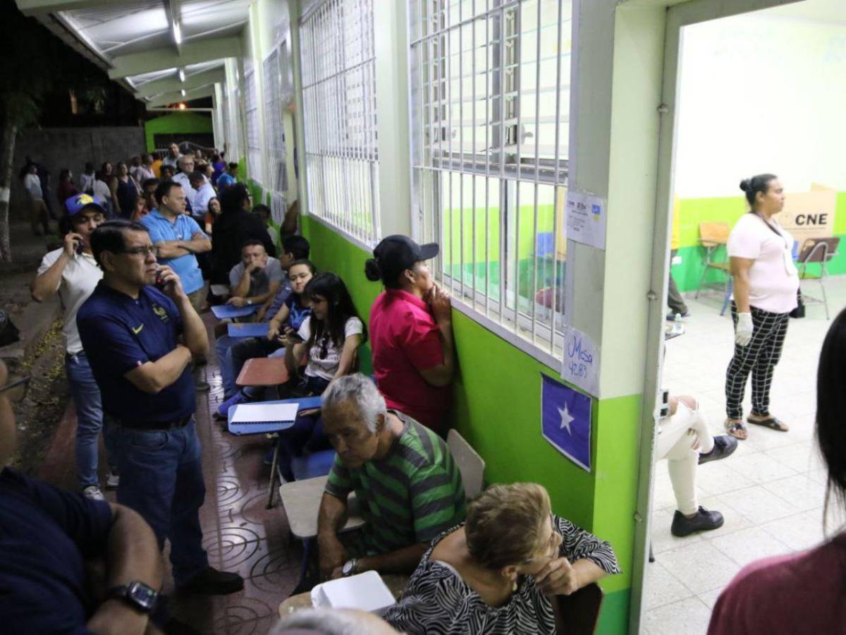 ¡A oscuras y cansados! Miles de hondureños se mantienen en centros de votación que abrieron tarde