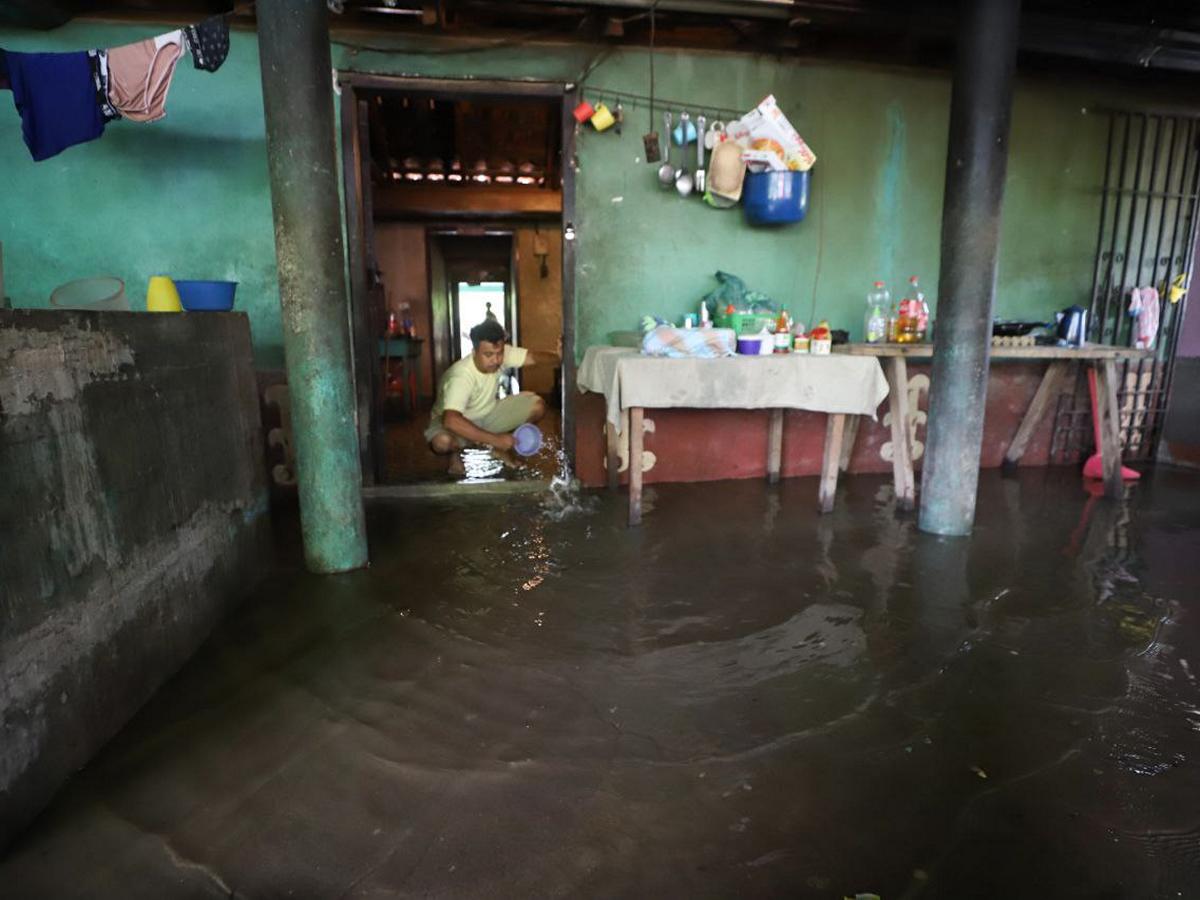 La vivienda de Orlando Reyes Castro, en El Aceituno, sacaba el agua que inundó su casa durante la noche.