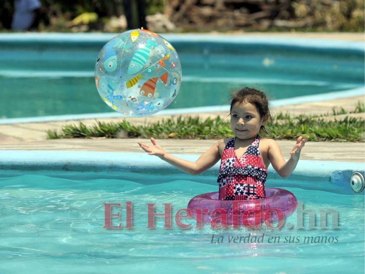 Una pequeña disfruta de su pelota inflable en el balneario La Roca en el pueblo selfi.