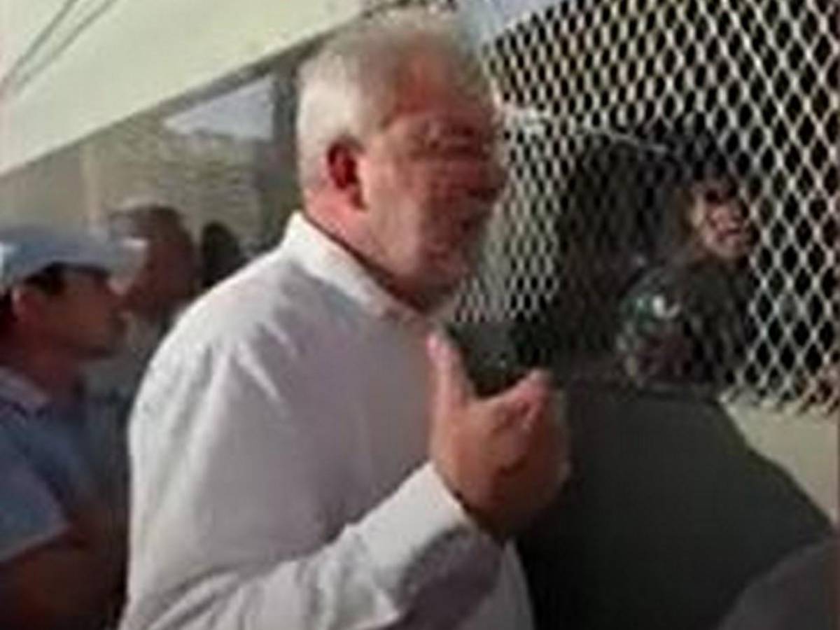 Roberto Contreras golpea portón de centro de votación que tardó en abrir urnas