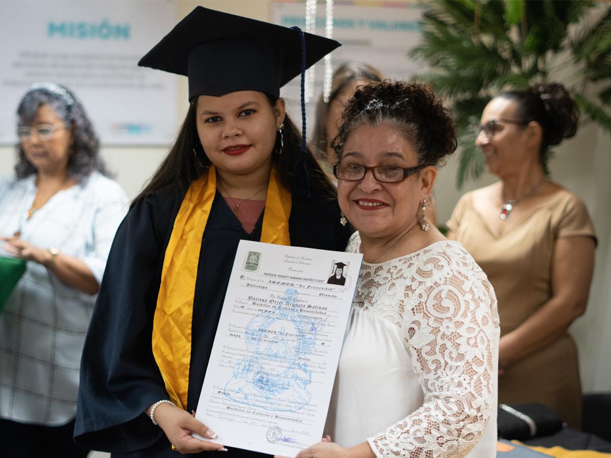 Tatiana Lara, delegada presidencial del Programa Ciudad Mujer, entrega certificado a una de las beneficiarias.