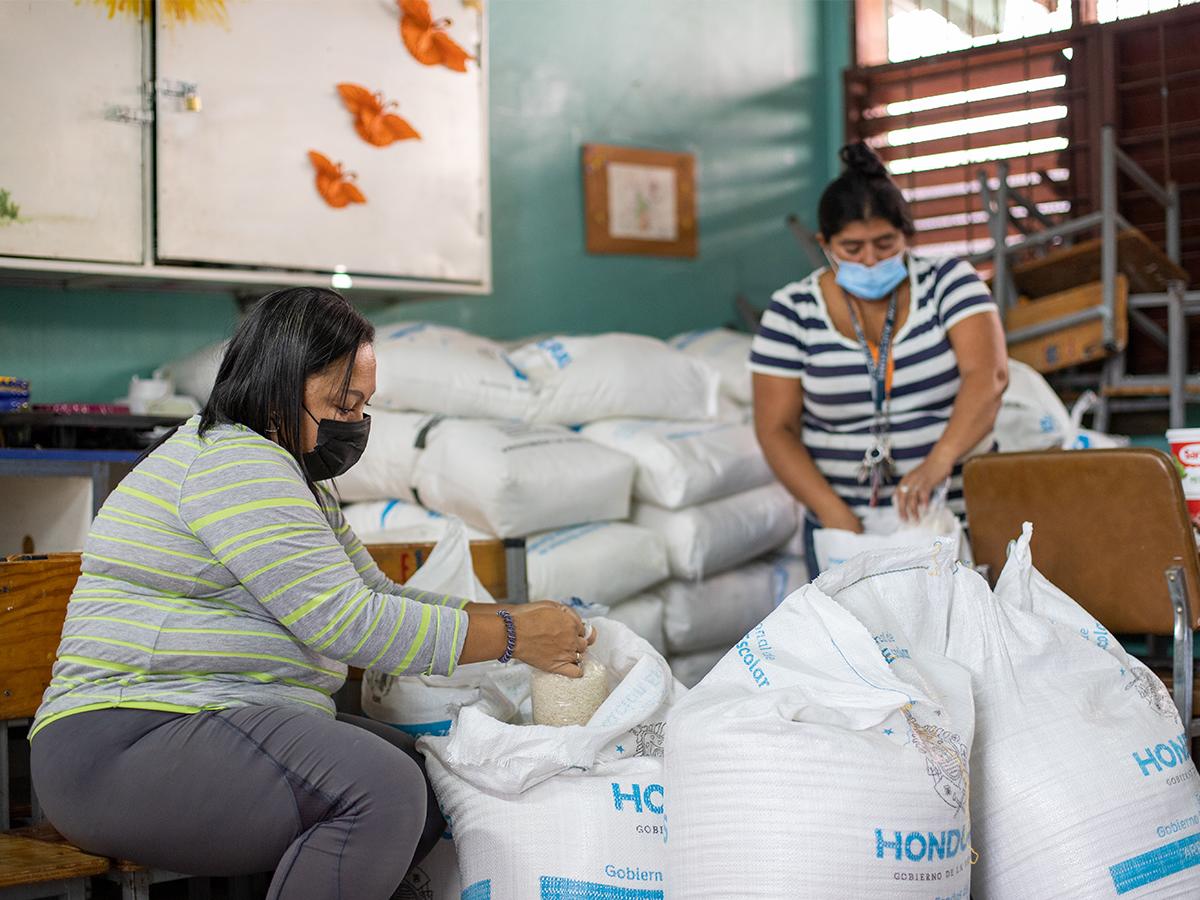 Personal de las escuelas dividiendo los granos básicos para ejecución de la merienda