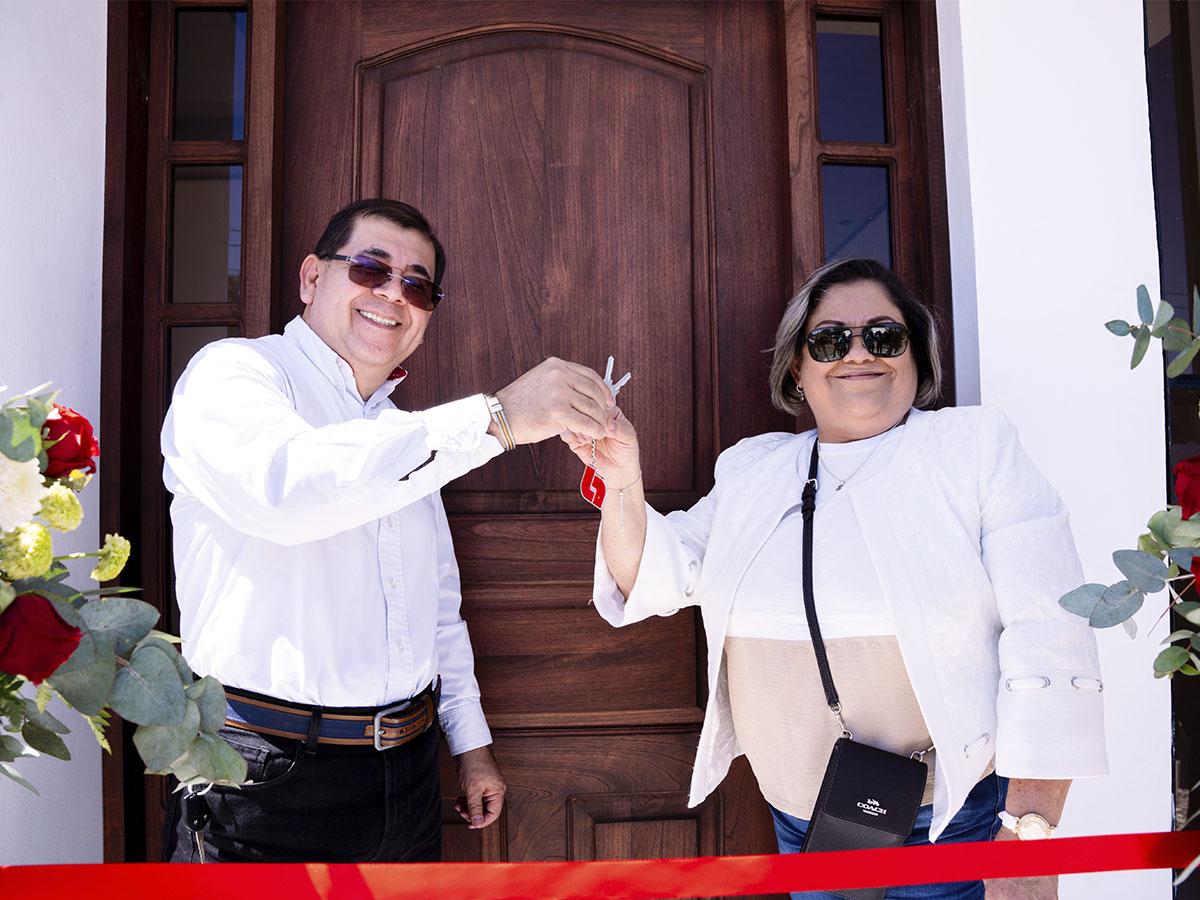 <i>Richard Alfaro, Gerente Comercial de Zona Occidente de Banco Atlántida junto a María Ninfa Zerón al momento de realizar el corte de cinta de su nuevo hogar.</i>