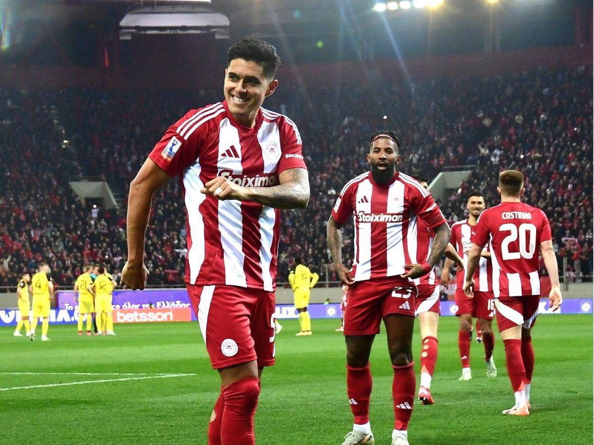Luis Palma anota su primer gol con el Olympiacos y lo celebra frente a jugador mexicano