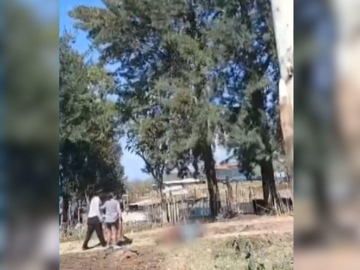 Momento en que el hombre acababa de atacar al joven, quien yace en el suelo.