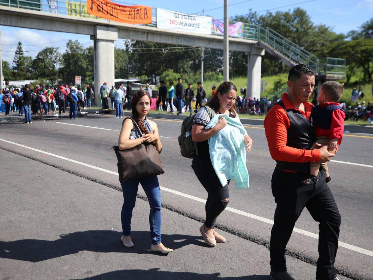 Con maleta en mano y niños en brazos, hondureños caminan por protesta en carretera CA-5