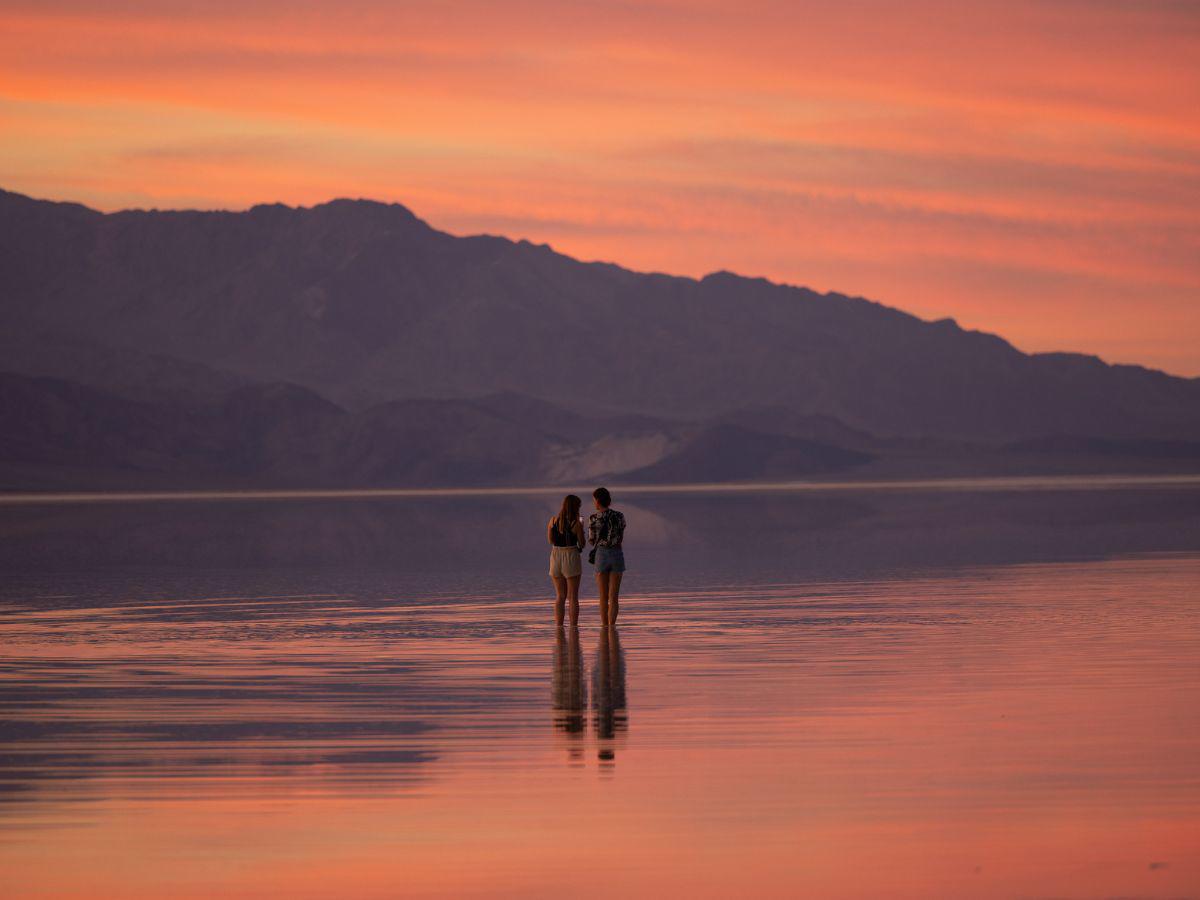 $!En el Parque Nacional del Valle de la Muerte, hogar de algunas de las temperaturas más altas, turistas vadean en un lago.
