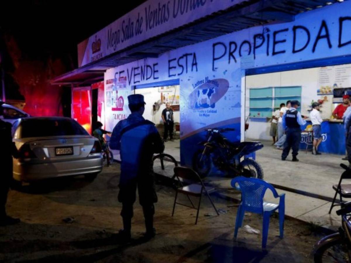 PolicÃ­a inspeccionando un bar que tiene el mensaje 'Se vende esta propiedad' escrito en la fachada, y donde varios hombres jugaban al billar en San Pedro Sula, Honduras,el miÃ©rcoles 1 de mayo de 2019. (AP Foto/Delmer Martinez)
