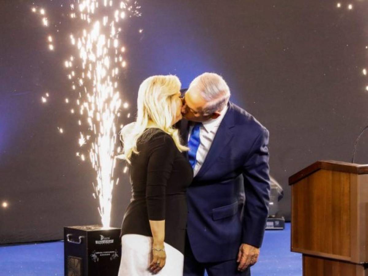 El primer ministro israelí Benjamín Netanyahu besa a su esposa Sara mientras se presenta ante sus seguidores en la sede de su partido Likud en la ciudad costera israelí de Tel Aviv, en la noche de las elecciones del 10 de abril de 2019. Foto AP