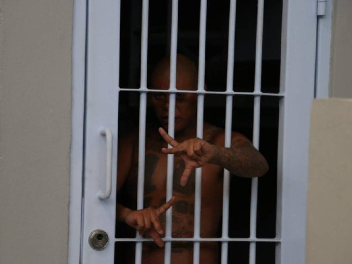 Entre los barrotes, manos y rostros completamente tatuados hacían señales particulares a la pandilla 18 y MS-13 en señal de bienvenida a la ahora temible cárcel de máxima seguridad El Pozo II.