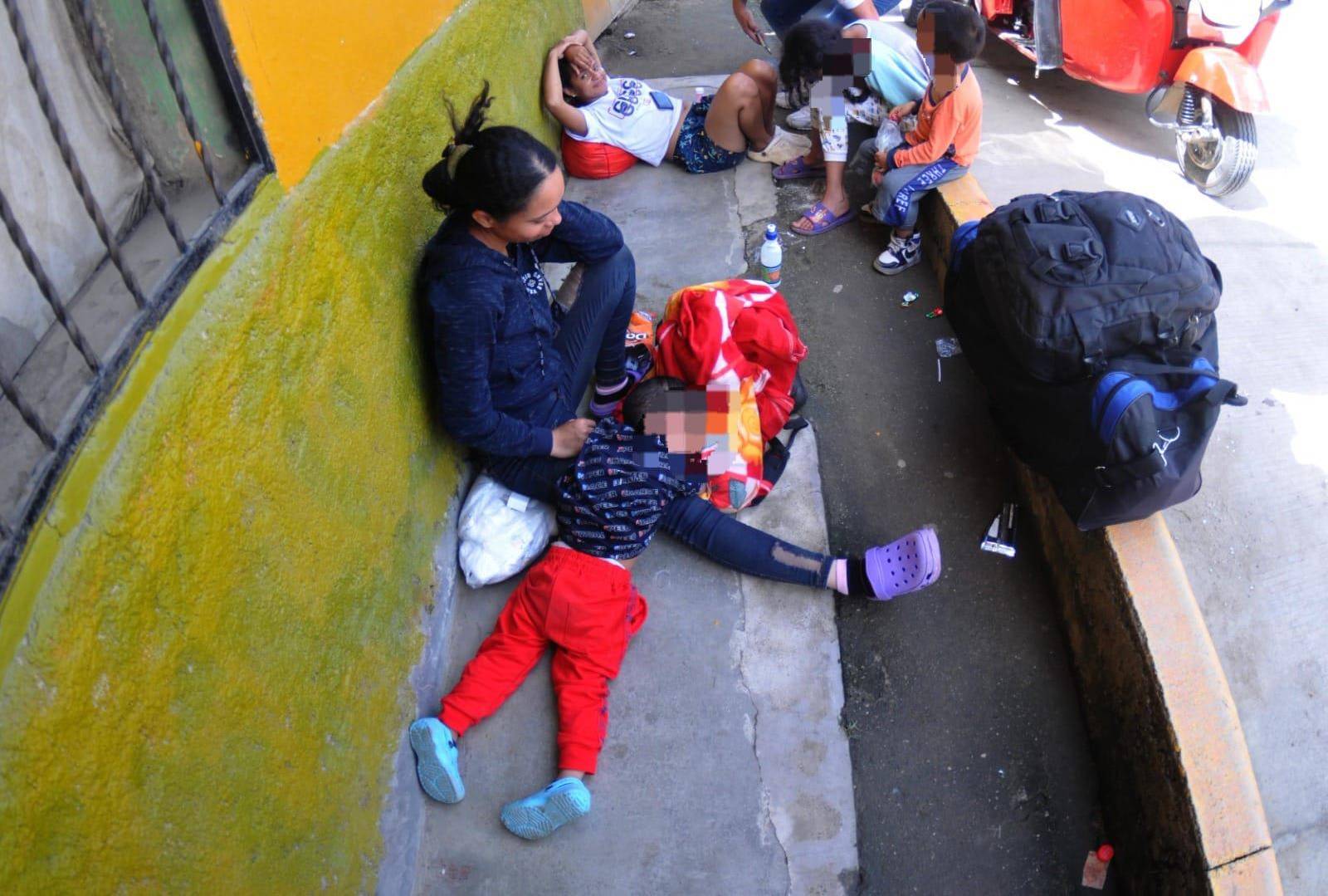 $!Estas dos familias venezolanas esperan en una acera en el municipio de Trojes, El Paraíso a inmediaciones del Instituto Nacional de Migración (INM) que les brinden un permiso para poder circular por Honduras.