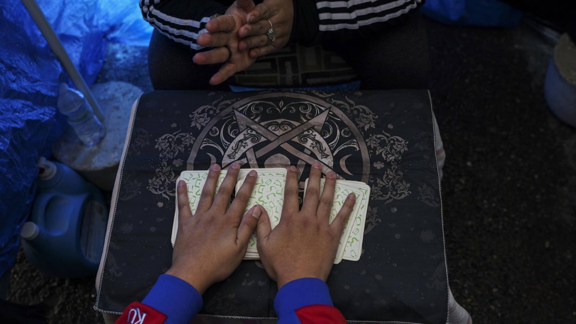 $!Clara Cavazos, de negro, se prepara para dar una lectura de cartas para un cliente en un mercado en Alamo, Texas.