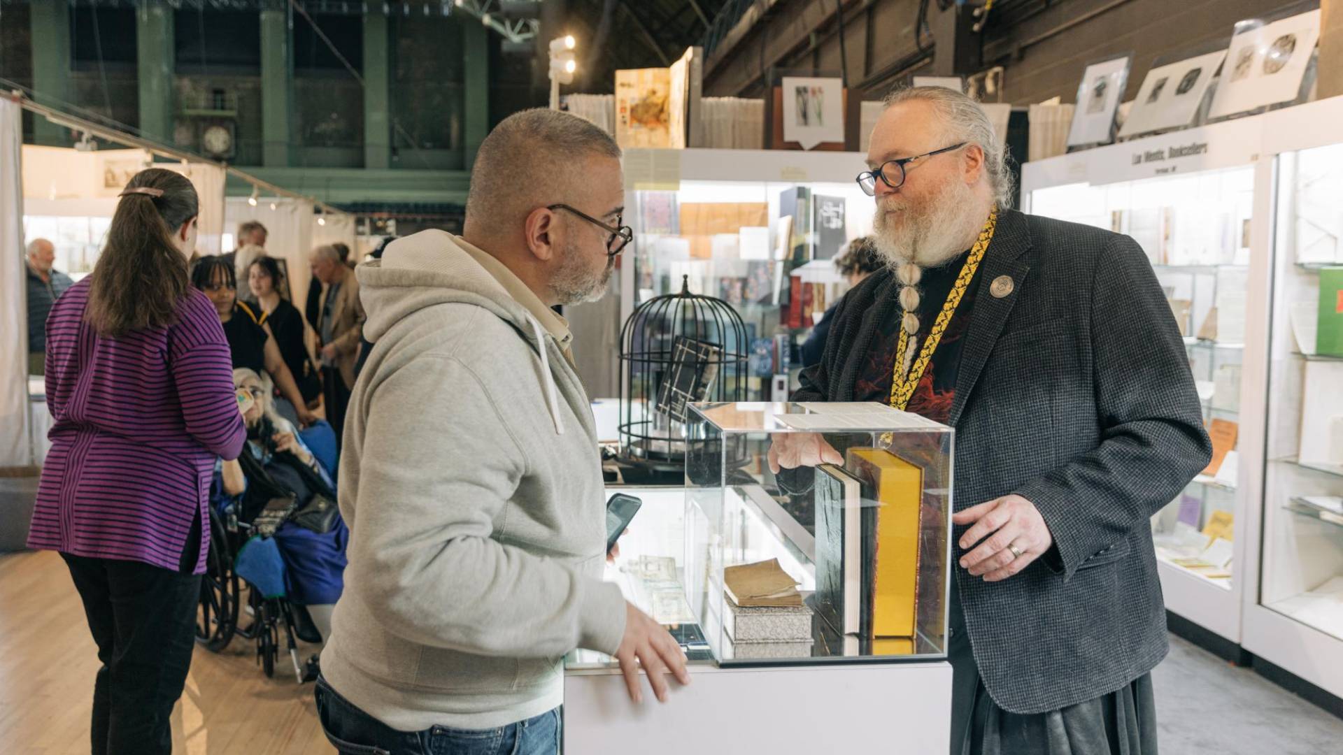 $!El librero Ian Kahn (der.) puso a la venta un volumen encuadernado en piel humana en una feria del libro.