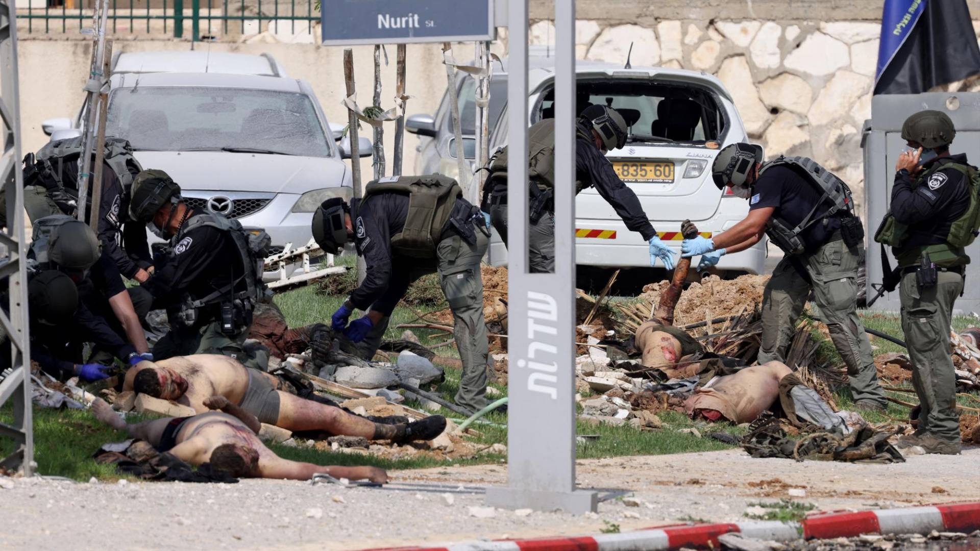 $!Soldados israelíes inspeccionan los cuerpos de combatientes palestinos muertos frente a una comisaría de policía en Sderot.