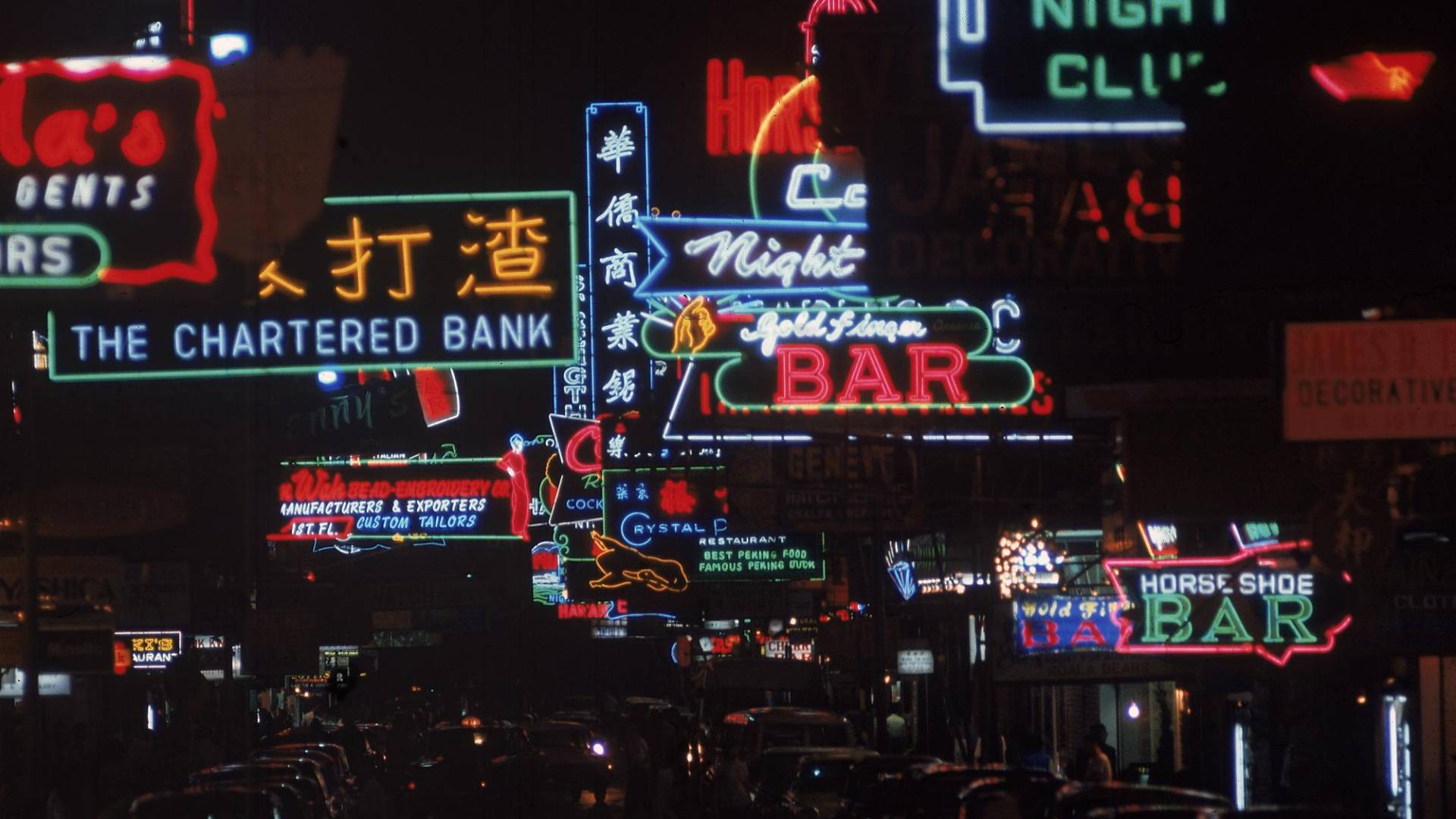 $!Una escena nocturna con coloridos rótulos de neón en inglés y chino, en Hong Kong, en los años 60.