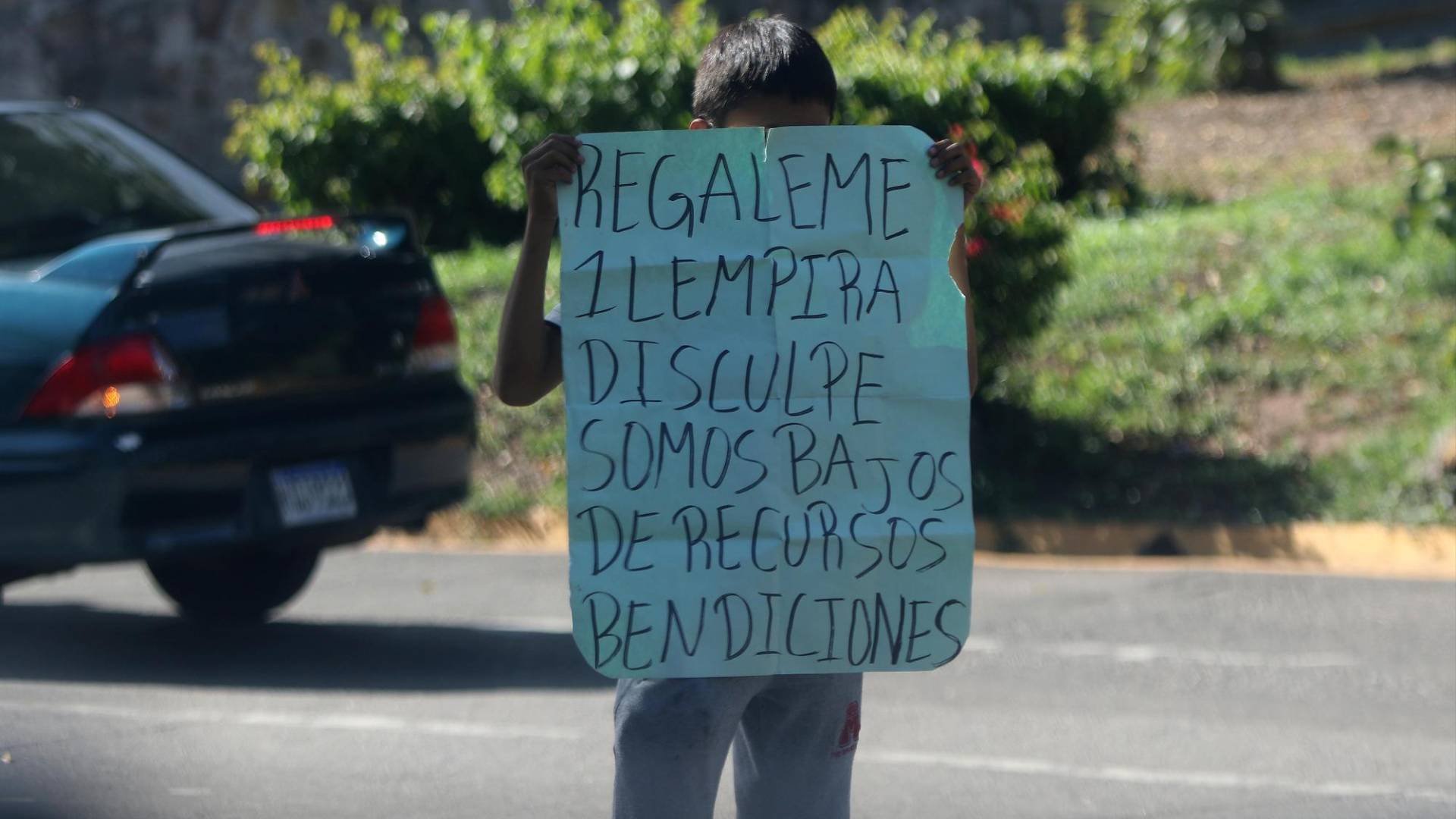 $!Con un rotulo en sus manos este pequeño solicita apoyo para obtener dinero