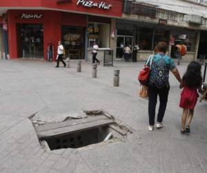 En plena peatonal se encuentra este enorme agujero que apenas tiene un par de tablas para evitar un accidente.Foto: Alejandro Amador/ EL HERALDO