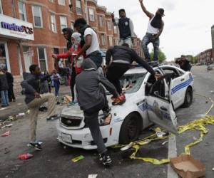 Jóvenes negros enfurecidos causaron destrozos a patrullas policiales.