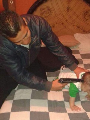 Apunta con arma a bebé