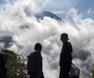 Un grupo de niño observa a lo lejos el volcán Turrialba.