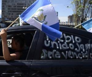 'El pueblo unido jamás será vencido', se lee en un vehículo cuyo conductor ondea la bandera de Guatemala.
