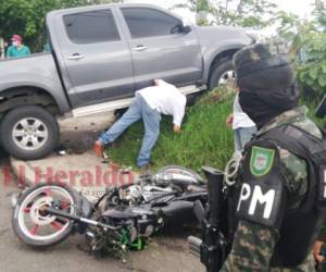 Algunos transeúntes ayudaron a sacar al joven de entre las pesadas llantas del vehículo Hilux. Foto: Estalin Irías/ EL HERALDO