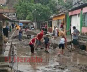 Vecinos del sector 2 de la colonia 3 de mayo se organizaron para intentar limpiar sus casas, afectadas por las intensas lluvias. Foto: Rommel Roque EL HERALDO