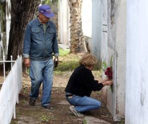 Una mujer coloca un arreglo floral en el Cementerio General. (Foto: David Romero)