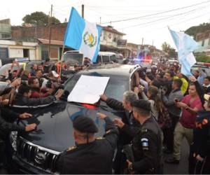 Manifestantes rodean el jueves el vehículo que lleva a Otto Pérez a la cárcel de Matamoros. (Foto: AFP)