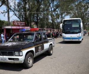Una patrullera de la policía escolta un autobús que transporta a migrantes centroamericanos que viajan con la caravana anual de 'Estaciones de la Cruz'. (AP Photo / Felix Marquez).