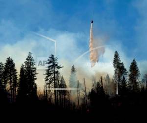 Un helicóptero arroja agua sobre un incendio cerca de Pulga, California, el domingo 11 de noviembre de 2018.