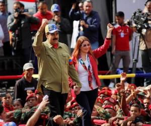 El presidente de Venezuela, Nicolás Maduro, y la primera dama, Cilia Flores, gesticulan ante sus partidarios durante una manifestación conmemorativa del aniversario del golpe fallido de 1992 encabezado por el difunto presidente Hugo Chávez en Caracas, Venezuela, el domingo 4 de febrero de 2018. Maduro se presentará a la reelección en la presente edición. elecciones presidenciales. (AP Photo / Ariana Cubillos).