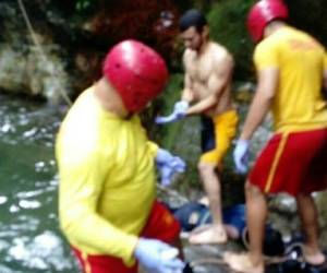 Momento en el que los rescatistas del Cuerpo de Bomberos de Honduras sacan el cadáver del joven.